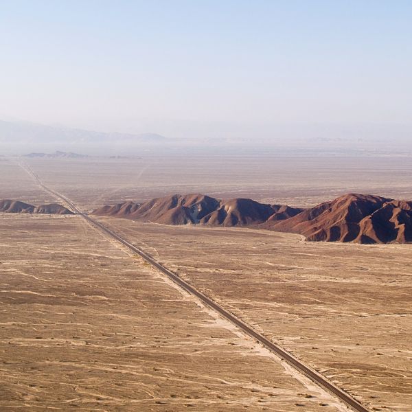 Aerial view of the reddish hills and flat plains of the Nazca desert