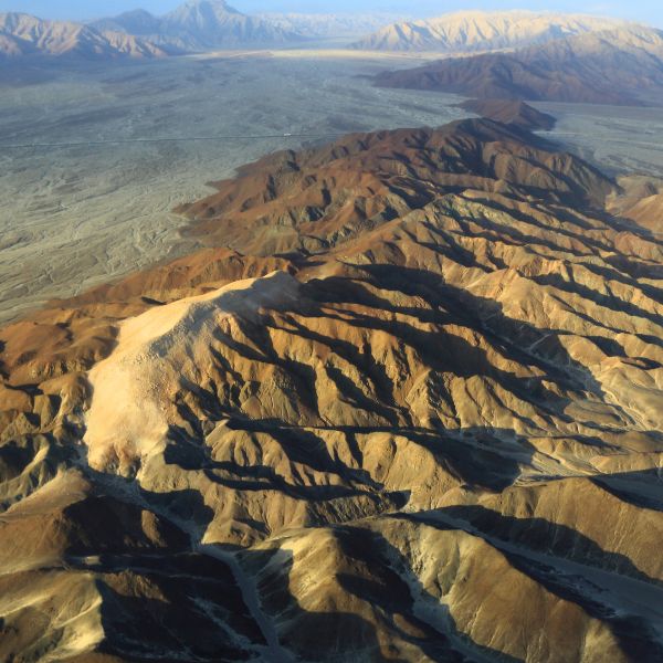 Dramatic aerial view of colorful desert mountain ridges.