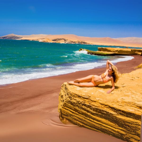 Woman sunbathing on the red sands of Playa Roja in Paracas Reserve