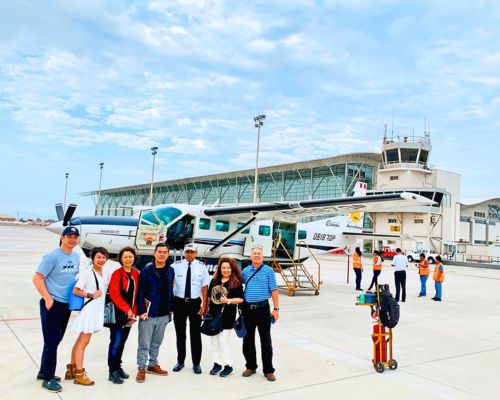Travelers with pilot and aircraft on Pisco Airport runway