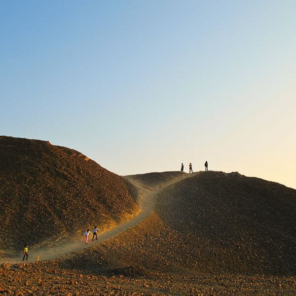 Visitors hiking Nazca desert hill