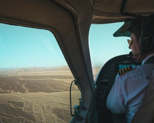 Pilot flying over the Nazca desert with geoglyphs below