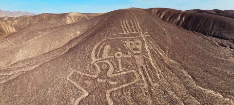 Large geoglyph of a human figure with intricate headgear on a Palpa hillside