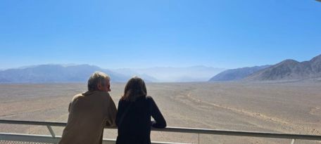 Two visitors observing the Nazca desert from the viewing platform