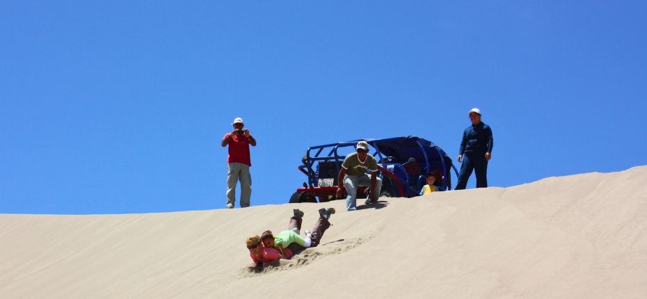 Sandboarding adventure in the Usaka Desert with dune buggy and guides