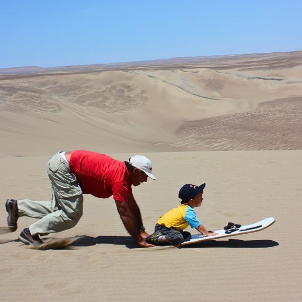 Family sandboarding experience in the desert