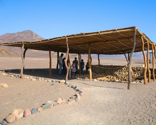 Wooden structure protecting ancient tombs at Chauchilla Cemetery.