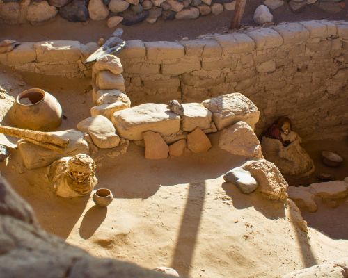 Ancient mummy with pottery offerings inside an open tomb at Chauchilla