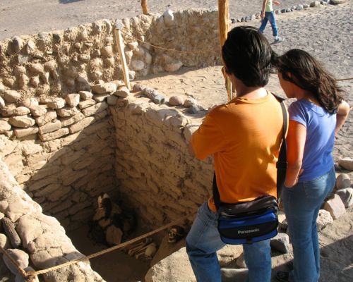 Tourists viewing an excavated tomb at Chauchilla Cemetery.
