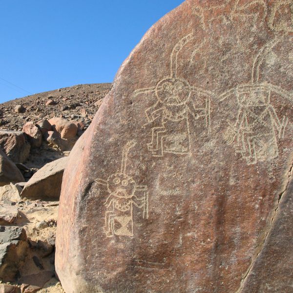 Rock carvings of three anthropomorphic priest-like figures.