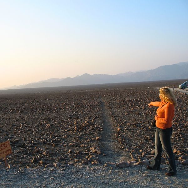 Tourist pointing at a Nazca geoglyph on the ground